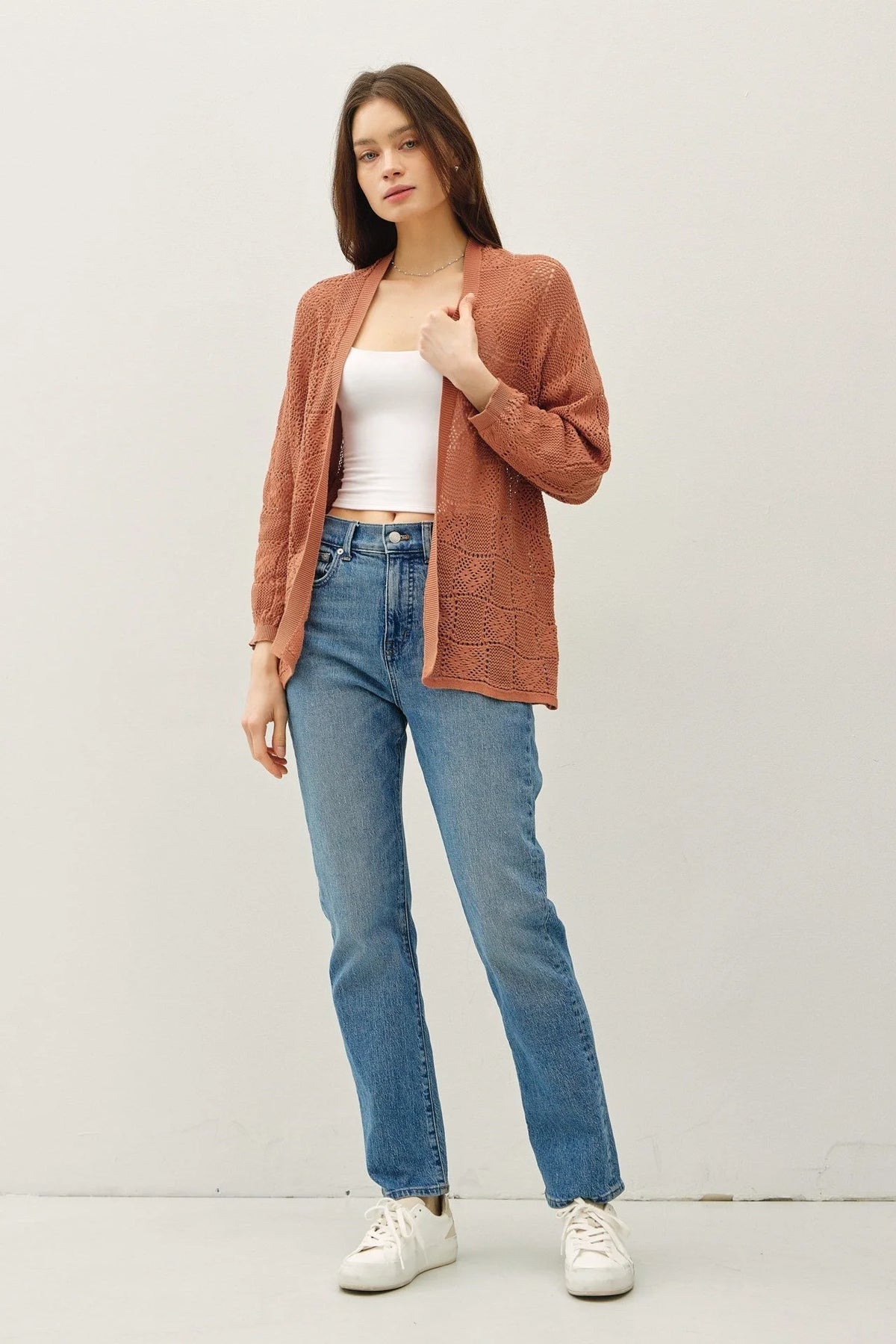 Woman wearing a crochet knit cardigan and jeans showcasing the crochet knit cardigan style