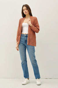 Woman wearing a crochet knit cardigan and jeans showcasing the crochet knit cardigan style