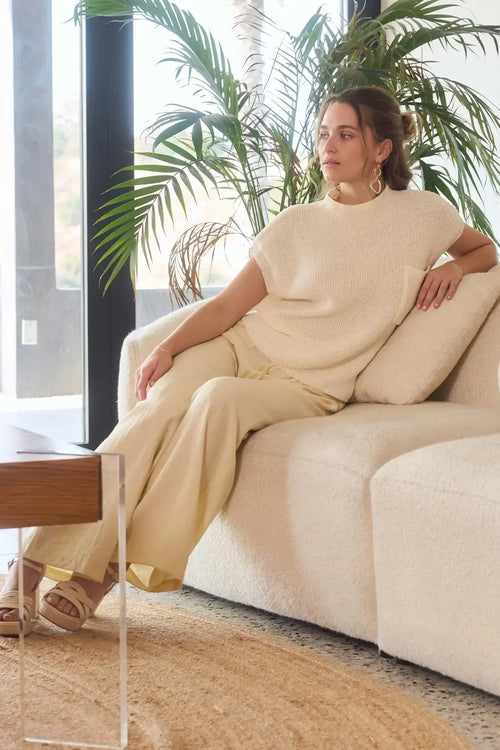 Woman in cream-colored lounge wear from shop Daisy, perfect for womenās boho chic clothing