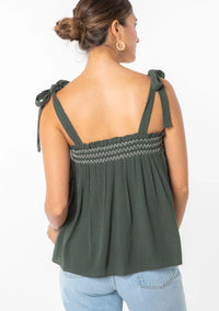 Woman wearing bohemian tie shoulder smocked tank top with shoulder ties in dark green
