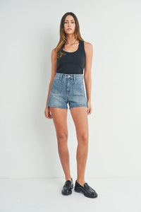 Woman in high rise patch pocket denim short and black tank top, showcasing stylish summer wear
