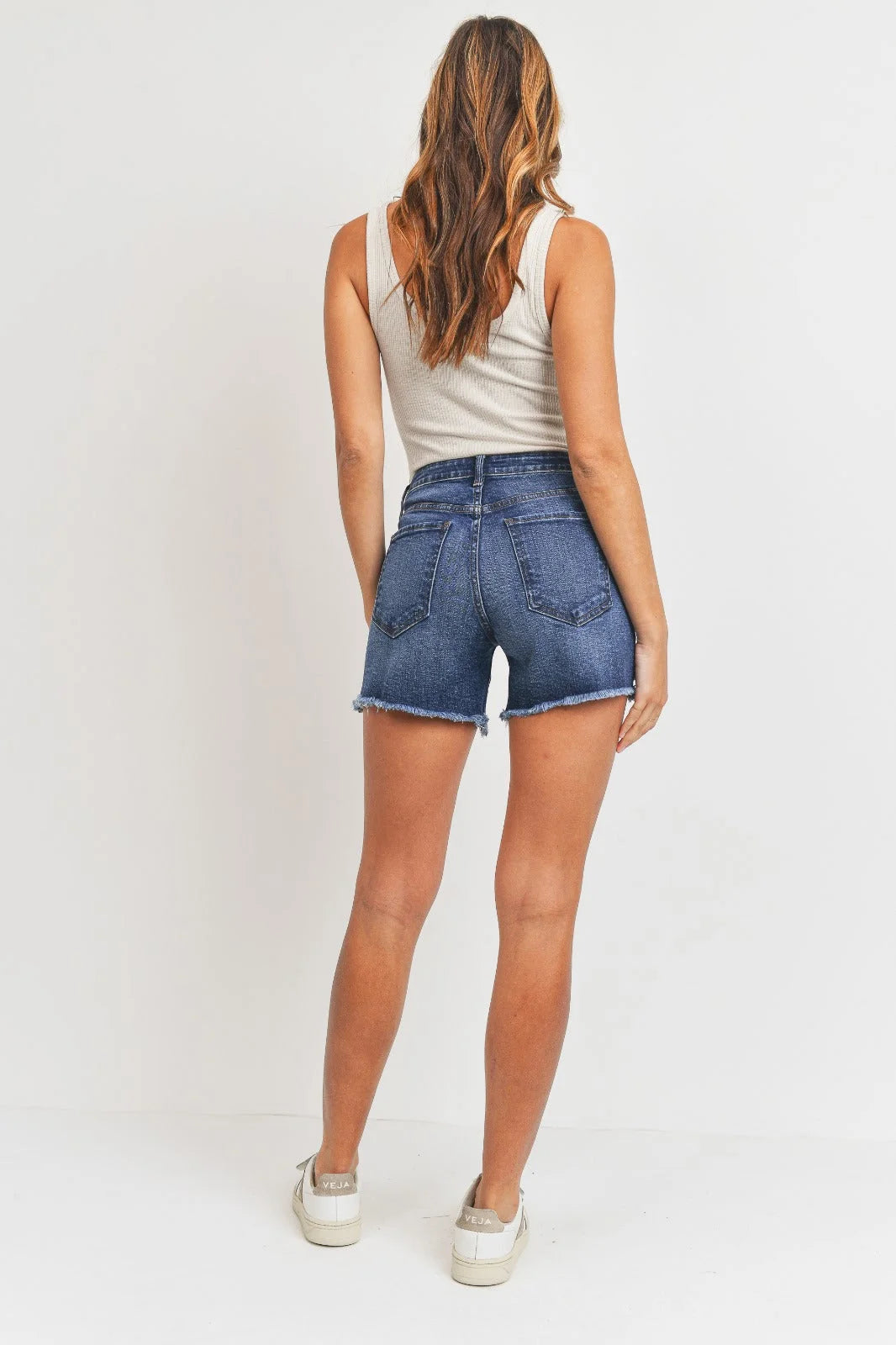 Woman wearing denim shorts from the MED-HI-LO Hem Detail Long Summer Short collection