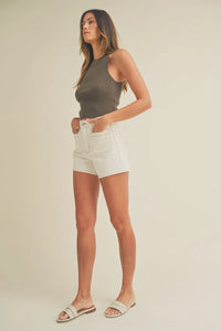 Woman in gray tank top and white shorts showcasing high rise patch pocket denim short