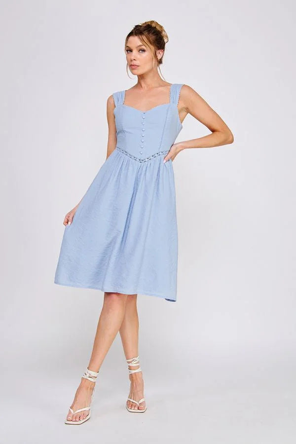Woman in a light blue wash textured woven fitted dress showcasing elegant style