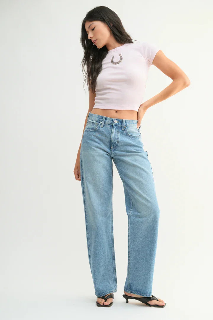 Woman in light blue straight leg jeans and a pink crop top from Shop Daisy