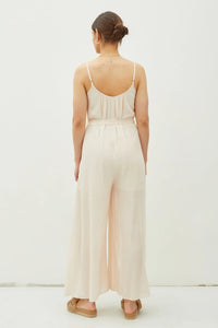 Woman in a light-colored jumpsuit with tie belt, perfect for women’s boho chic clothing