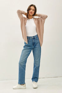 Woman wearing beige and white striped dolman sleeve open cardigan with white t-shirt and blue jeans