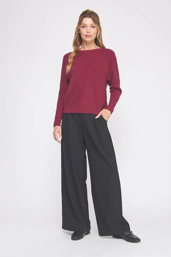 Woman wearing FINE GAUGE BOAT NECK SWEATER with relaxed black trousers and loafers