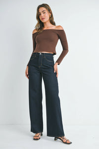 Woman wearing high rise relaxed wide leg denim jeans with off-the-shoulder crop top and heels