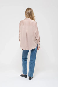 Woman in pale pink oversized shirt and blue jeans showcasing Satin Pinstripe Button Up Top