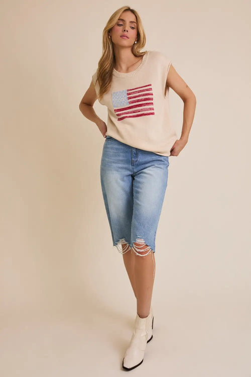 Woman wearing a patriotic shirt and denim capris showcasing the wide shoulder US USA flag sweater