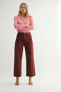 Woman wearing pink cardigan and brown high-rise barrel denim jeans showcasing women’s boho chic clothing at Shop Daisy