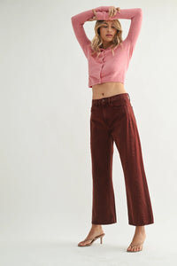 Woman wearing pink cardigan and maroon jeans showcasing high rise barrel denim jean twist from Shop Daisy