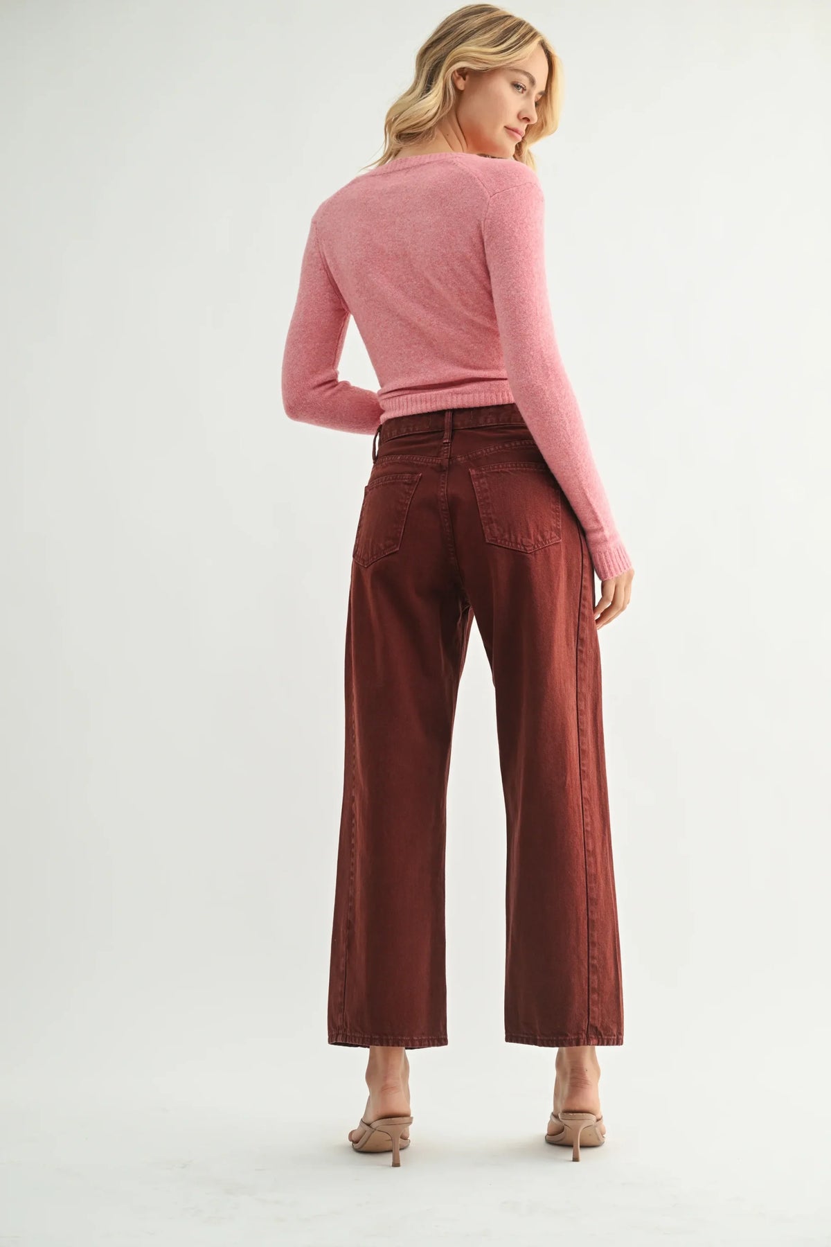 Woman in pink top and wide-leg brown jeans, perfect for women’s boho chic clothing at Shop Daisy