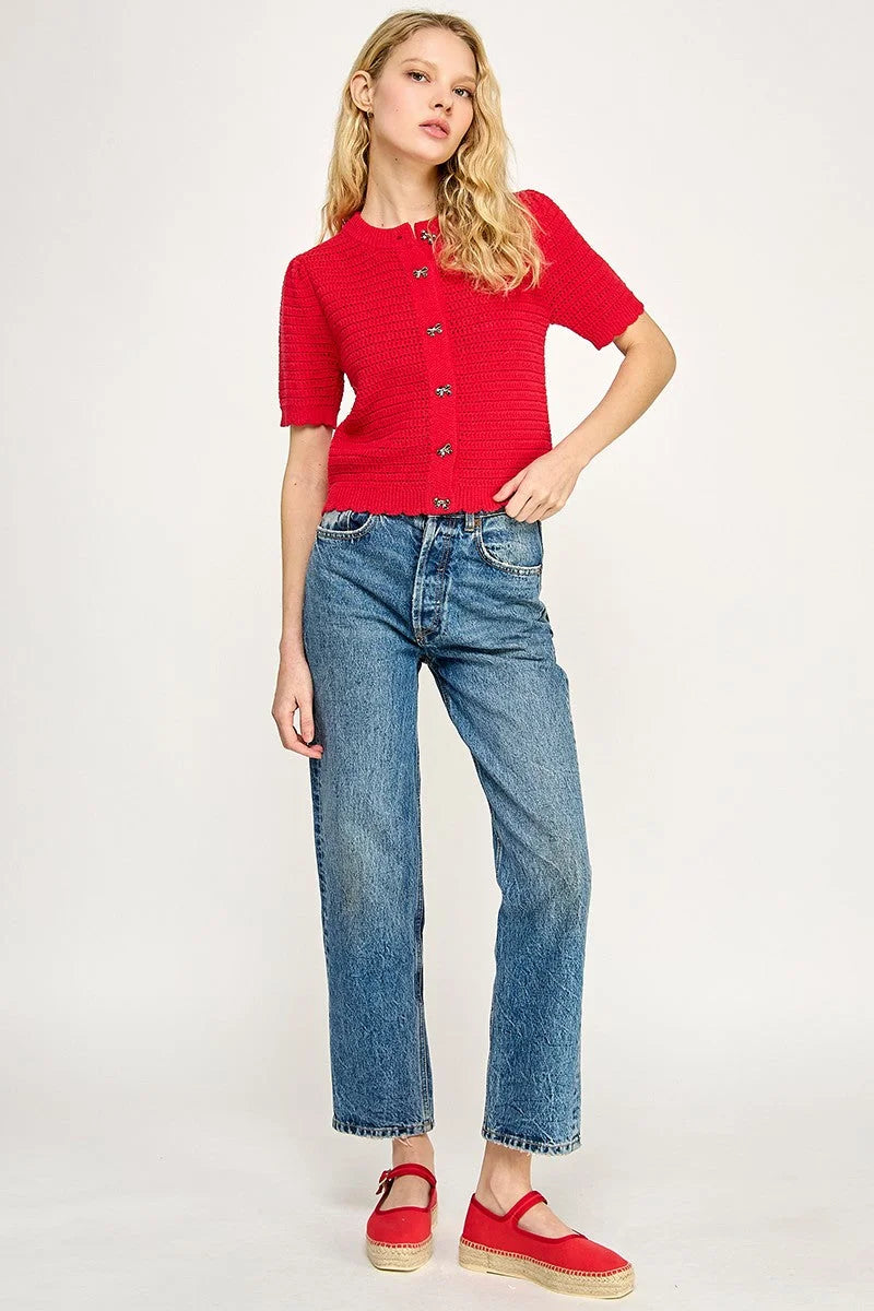 Woman in red cardigan and blue jeans wearing women’s boho chic clothing from Shop Daisy