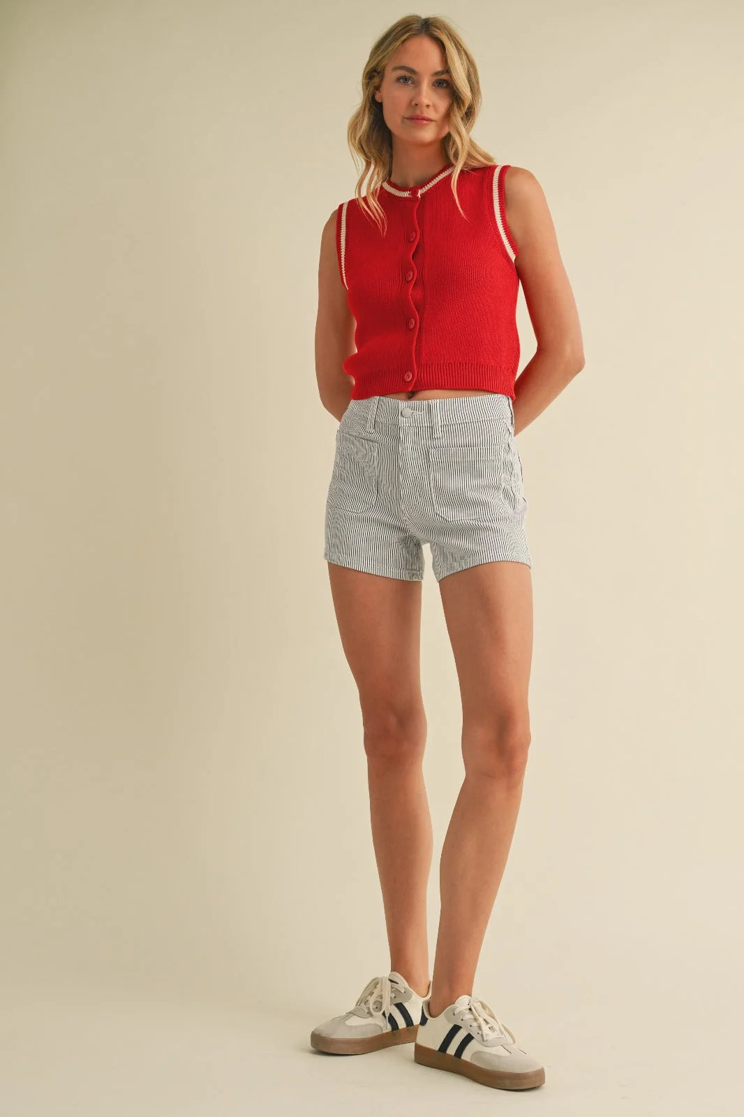 Woman in high rise denim shorts with patch pockets wearing a red top