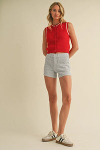 Woman in high rise denim shorts with patch pockets wearing a red top