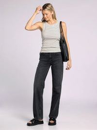 Woman wearing the Edlin Basic Tank, styled with dark jeans and a striped design