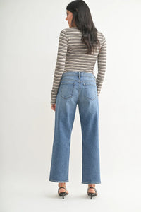 Woman in striped top and wide-leg jeans showcasing Mid Rise Stretch Bow Boyfriend style