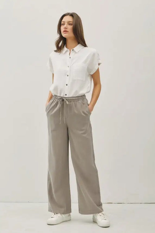 Woman wearing stylish gray wide-leg pants with pockets, ideal for womenās boho chic clothing at Shop Daisy