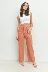 Woman in a white crop top and terracotta pants showcasing Nautical Wide Leg style
