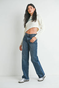 Woman modeling white cropped cable-knit sweater with blue distressed straight leg jeans for women’s boho chic clothing at Shop Daisy