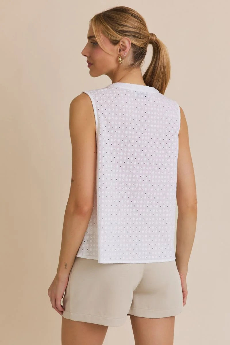 Woman in white eyelet tank top and beige shorts, showcasing women’s boho chic clothing from Shop Daisy