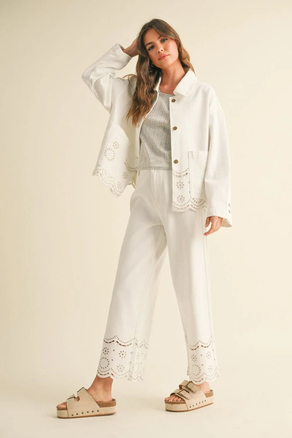 Woman in white laser-cut jacket and EMBROIDERY BOTTOM PANTS from Shop Daisy’s women’s boho chic clothing