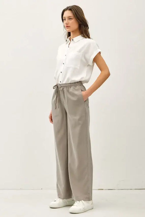 Woman wearing white shirt and gray wide leg pants with pockets, ideal for womenās boho chic clothing from Shop Daisy