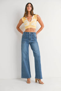 Woman modeling yellow crop top and patch pocket wide leg flare denim jeans with light brown heels