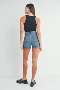 Woman’s high rise patch pocket denim shorts paired with a stylish black tank top