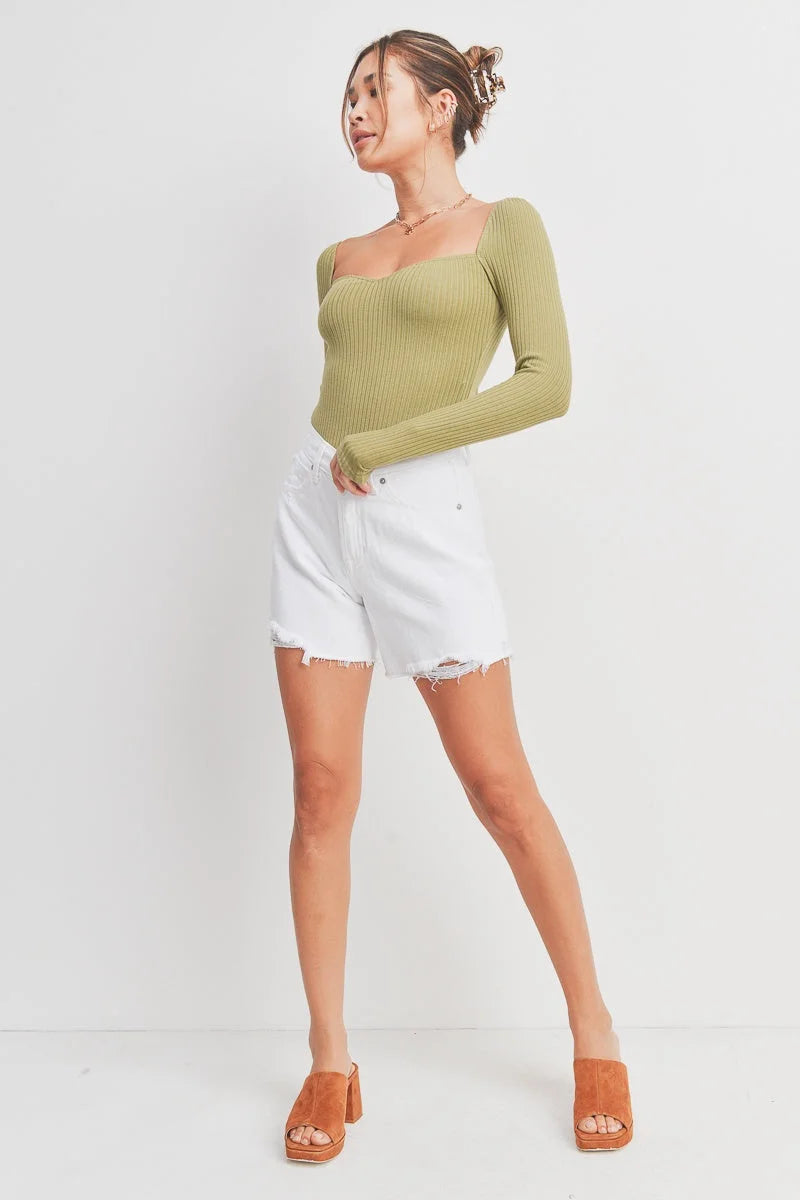 Woman wearing green ribbed long-sleeve top and white denim shorts from Summer Boyfriend Short, ideal for women’s boho chic clothing at Shop Daisy