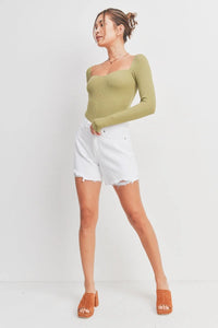 Woman wearing green ribbed long-sleeve top and white denim shorts from Summer Boyfriend Short, ideal for women’s boho chic clothing at Shop Daisy