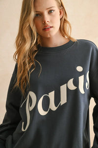 Woman’s dark gray Paris patch sweatshirt featuring white script, ideal for women’s boho chic clothing from Shop Daisy