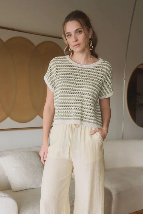 Woman wearing striped crochet knit batwing sweater with wide-leg pants, ideal womenās boho chic clothing from Shop Daisy