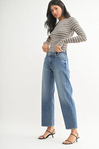 Woman wearing a mid rise stretch Bow Boyfriend shirt with wide-leg jeans
