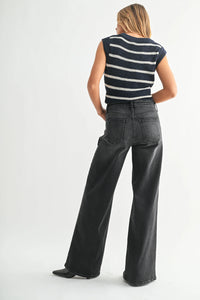 Woman wearing high-rise bohemian wide-leg denim jeans and striped sleeveless sweater