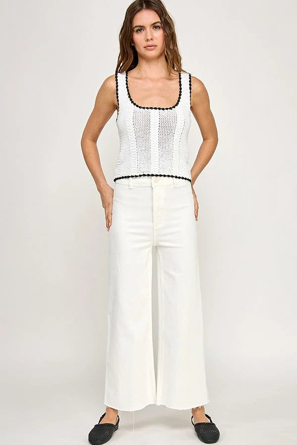 Woman in a white knit tank top paired with high-waisted straight pants jeans outfit