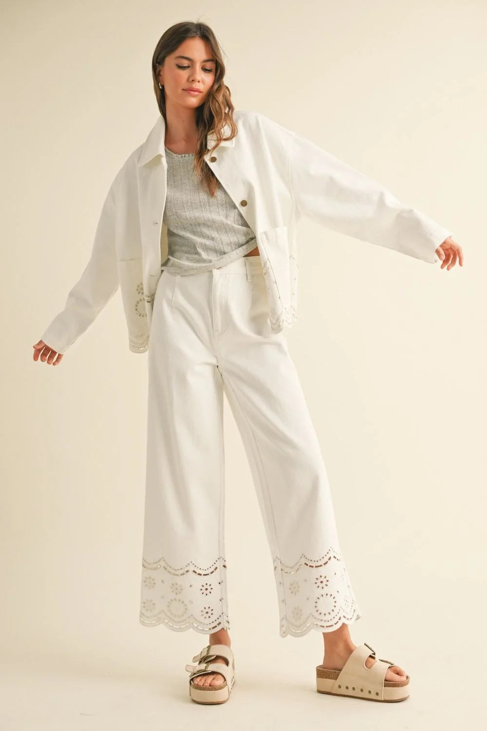 Woman in a stylish white pantsuit from Shop Daisy, embodying women’s boho chic clothing