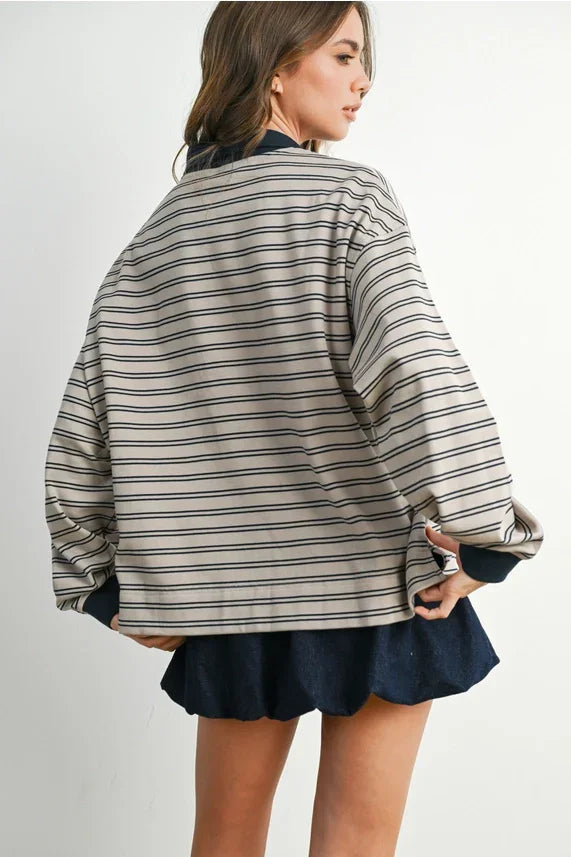 Beige and black striped collared long sleeve shirt paired with a dark blue mini skirt