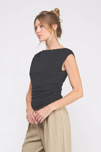 Black sleeveless boat neck scrunch tank top with side ruching and tan pleated trousers