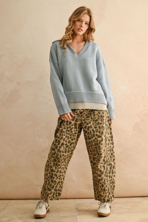 Womenās light blue color combo V-neck sweater layered over a lighter top with leopard print pants
