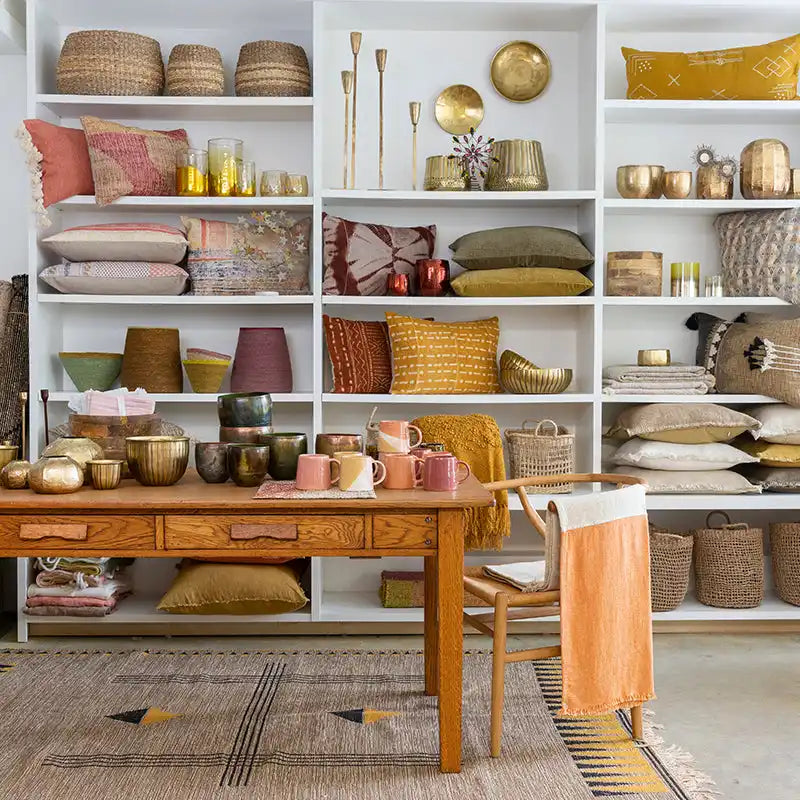 White shelving unit filled with decorative home accessories in warm earth tones.