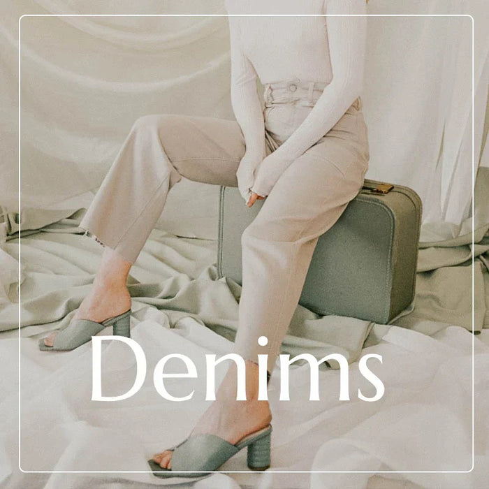 Light-colored trousers showcased by a person sitting on luggage in Bohemian Denims collection.