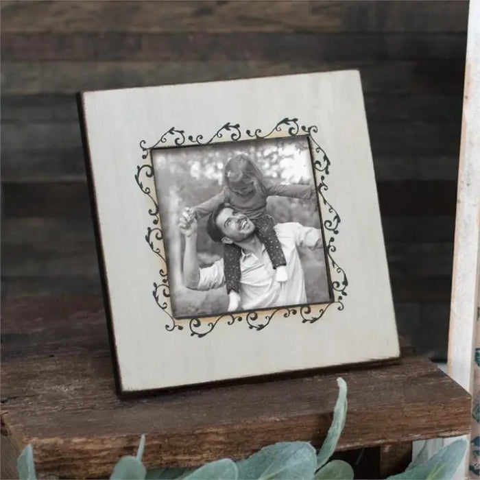 Ornate white frame displaying a black and white photograph in Daisy Lane home decor.