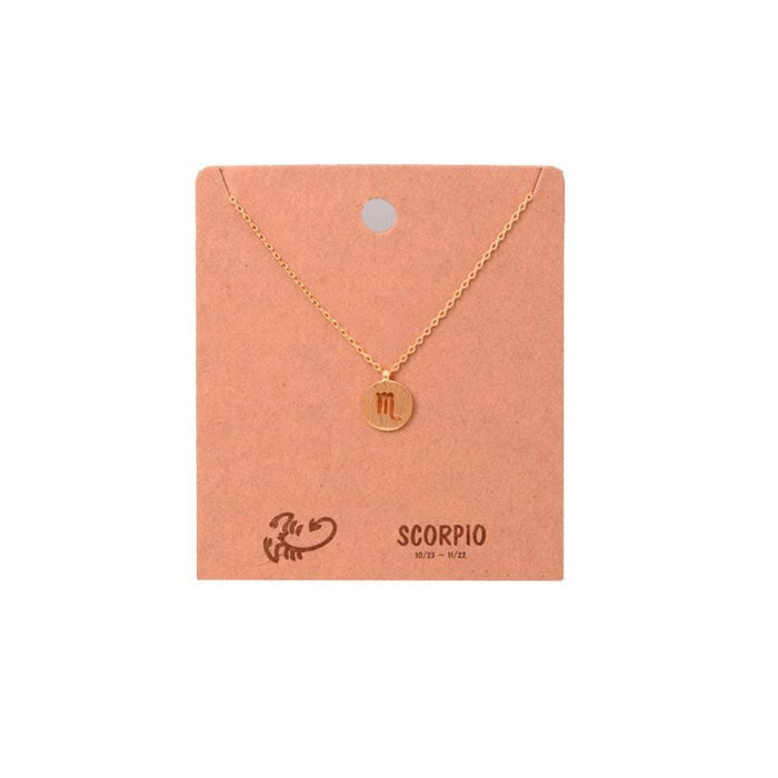 Gold Zodiac Sign Necklace for Scorpio on a Peach Display Card by Daisy Lane.