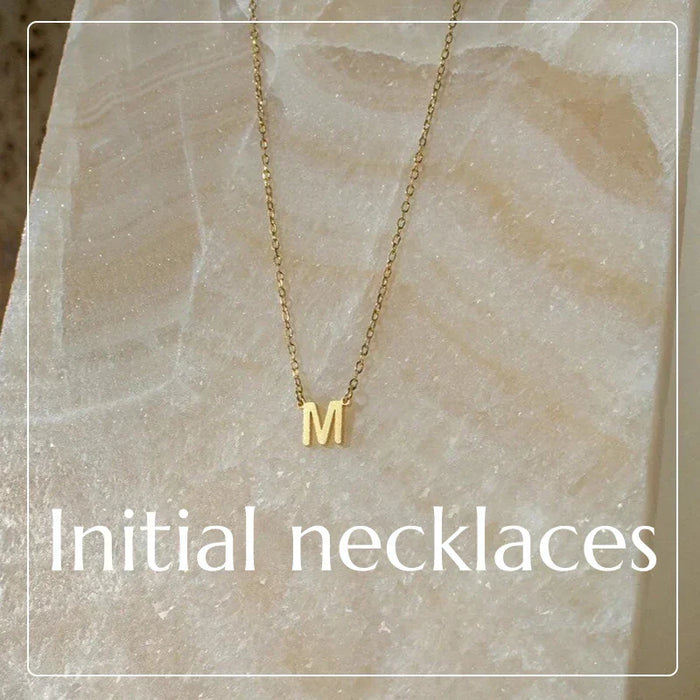 Gold-colored dainty initial pendant necklace with letter M from Daisy Lane collection.