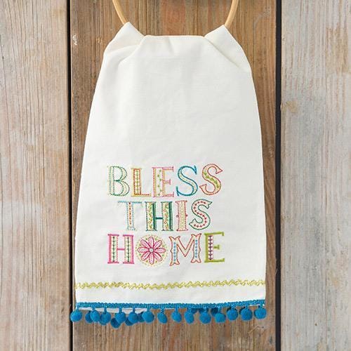 Decorative white kitchen towel with embroidered ’Bless This Home’ and blue tassels for boho style.