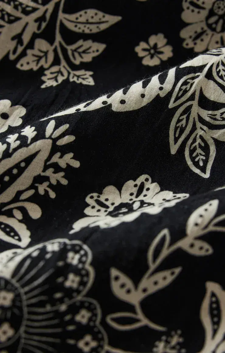 black and white floral midi dress with halter neck and flowing asymmetrical hemline perfect for summer wear
