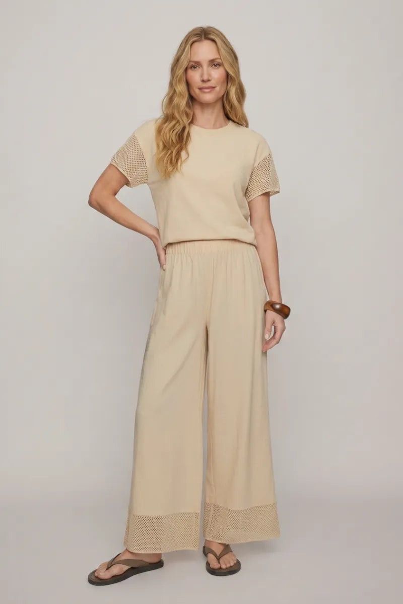 Beige short-sleeved top with mesh detailing paired with banyan crochet relaxed pants for a stylish casual look